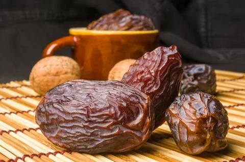 Big luxury dried date fruit in bowls on the bamboo mat, kurma ramadan kareem  Stock Photos