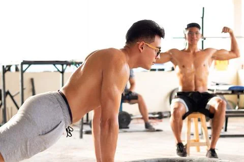 Big man doing push-ups in rustic gym. Stock Photos