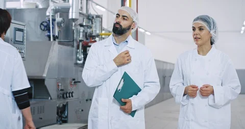 In a big manufacturing industry two young engineers walking through the Stock Footage 115636773