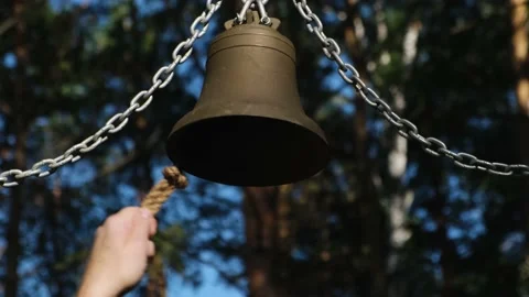 Big metal bell hanging on chains outdoor. Hand rings the bell, close up. Stock Footage 217866790