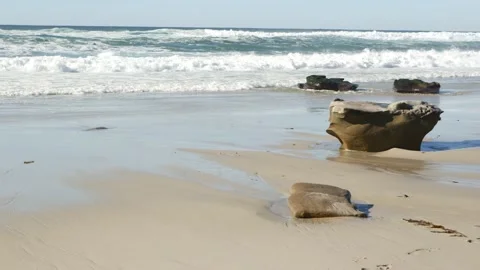 Big ocean wave crashing on beach, California coast, eroded stone or rock on sand Stock Footage 201018951
