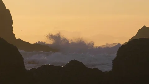 Big ocean waves between cliff rocks at sunset birds flying cannon beach Vidéo 122806308