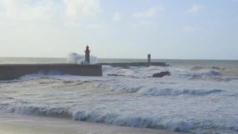 Big ocean waves crash and break on concrete breaker next to lighthouse Stock Footage 293614375