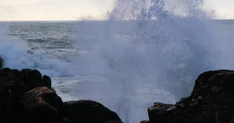 Big ocean waves hit and crush the rocks. Splash cold water drops in slow motion Stock Footage 273407063