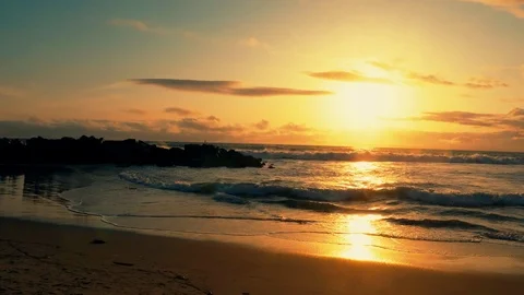 Big ocean waves hitting across huge stones with birds flying over at dusk. Видео 106850771