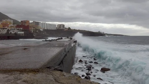 Big ocean waves hitting shore of city creating a lot of foam Bajamar, Tenerife Video stock 122664163