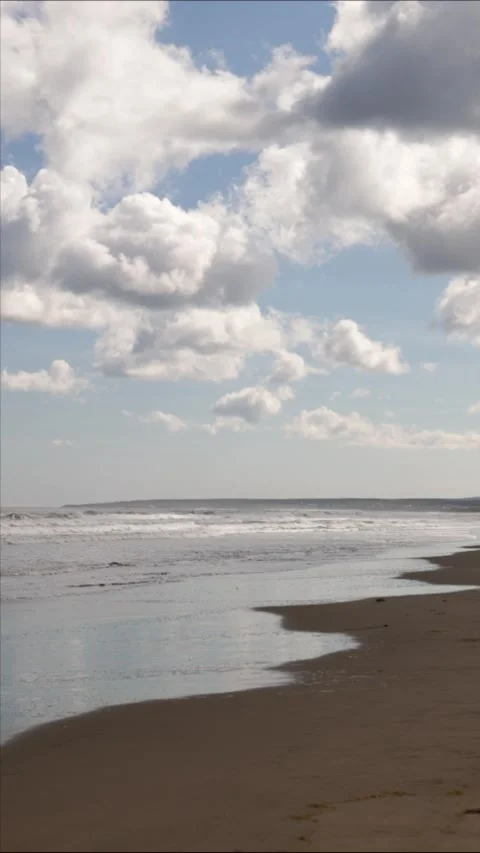 Big ocean waves near sandy beach and cumulus white clouds above water Stock Footage 309408521