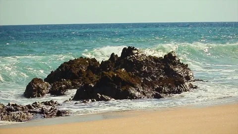 Big ocean waves rushing over jagged rocks by the beach. slomo B Stock Footage 107009199