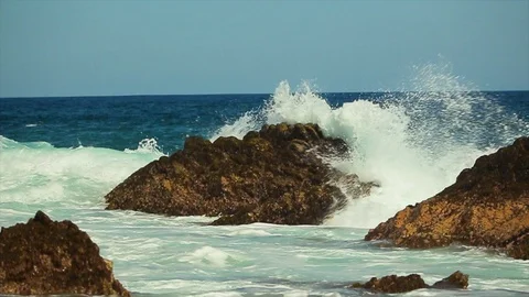 Big ocean waves rushing over jagged rocks by the beach. slomo A Stock Footage 107009211