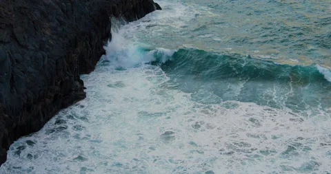 Big ocean waves at sunset. Aqua blue waves crash into black lava rock shore Stock Footage 198512409