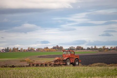 Big old model tractor plows the ground Stock Photos