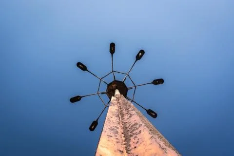 Big old rusty lighting 8 way on the pole under blue sky Stock Photos