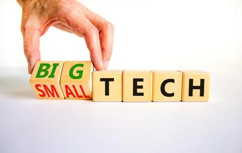 Big or small tech symbol. Businessman turns wooden cubes and changes concept  Stock Photos