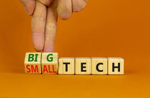 Big or small tech symbol. Businessman turns wooden cubes and changes concept  Stock Photos