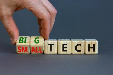 Big or small tech symbol. Businessman turns wooden cubes and changes concept  Stock Photos