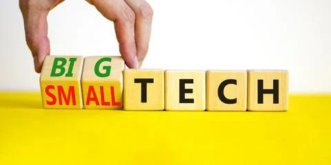 Big or small tech symbol. Businessman turns wooden cubes and changes concept  Stock Photos