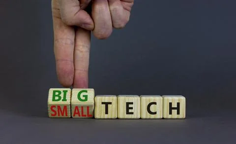 Big or small tech symbol. Businessman turns wooden cubes and changes concept  Stock Photos