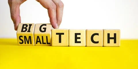 Big or small tech symbol. Businessman turns wooden cubes and changes concept  Stock Photos