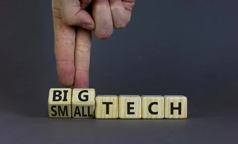 Big or small tech symbol. Businessman turns wooden cubes and changes concept  Stock Photos