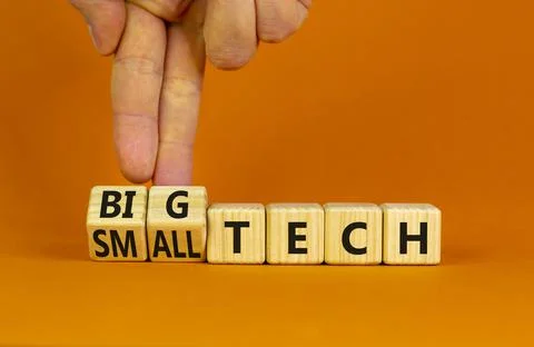Big or small tech symbol. Businessman turns wooden cubes and changes concept  Stock Photos