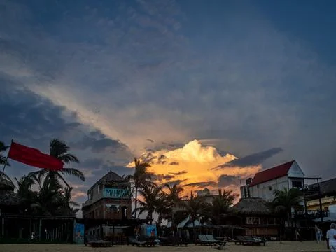 A big orange cloud with hotels on the beach in front of it Stock Photos