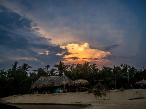 A big orange cloud with hotels on the beach in front of it Stock Photos