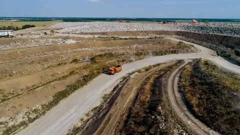 Big Orange garbage Truck moves through a huge landfill a Huge Garbage Dump Stockbeeldmateriaal 114472753