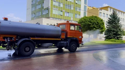 Big orange machine clears the asphalt with directed water streams. Stock Footage 208287015
