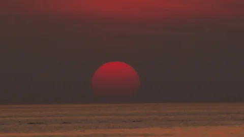 Big orange sun falling down into the deep sea in the golden twilihgt evening  Video stock 126754950