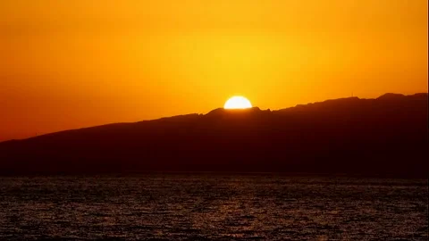 The big orange sun sets behind the mountains on the horizon Stock Footage 337426488