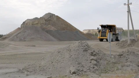 Big orange trucks moving around the territory of a granite factory Stock Footage 112937620