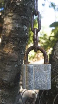 Big padlock hangs on a rusty chain Stock Photos