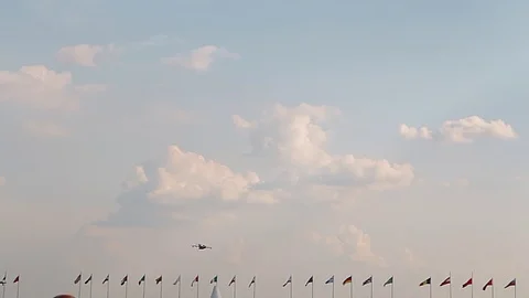 Big passenger plane in the blue sky. Country flags. A general plan. Aerobatic Stock Footage 124162299