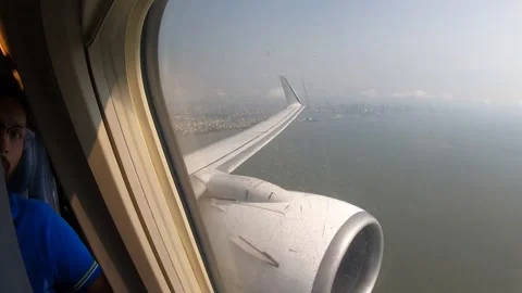 A big passenger plane flying over the coastal city and blue ocean. Stock Footage 135867653