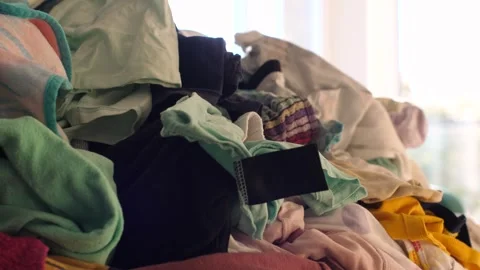 Big pile of clean clothes lying on a couch, laundry waiting to be folded Video stock 291669176