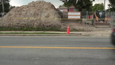 Big pile of dirt behind silver fence with building permits on bulletin board Vídeos de archivo 247753062