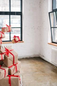 Big pile of gift boxes with red ribbons on white bricks background 写真素材