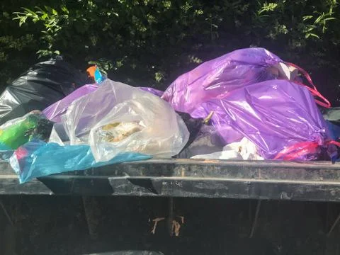 Big pile of plastic trash bags in trash container. Stock Photos