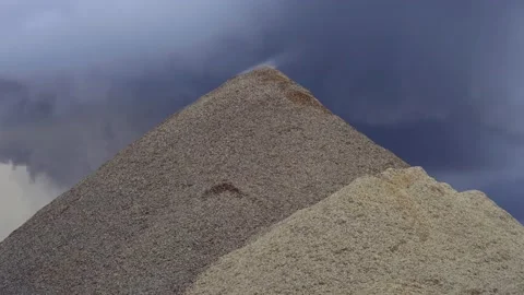 Big pile of steaming sawdust with dramatic sky in the back Stock Footage 144688565