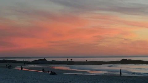Big pink sky sunset over beach with people 库存影片 79023744