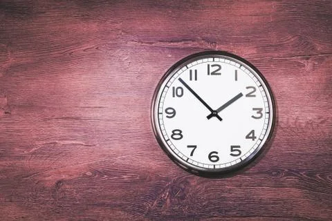 Big plain wall clock on rustic wooden background Stock Photos