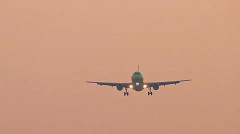 Big plane landing at sunset sky, flying airplane on red sunrise sky 스톡 동영상 65664338