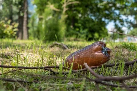 Big plastic bottle dumped on the grass in the park polluting the nature Stock Photos