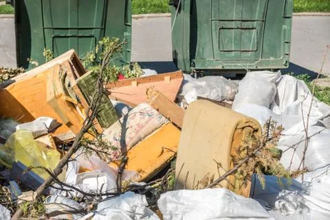 Big plastic dumpster garbage can overflow litter polluting street in the city Stock Photos