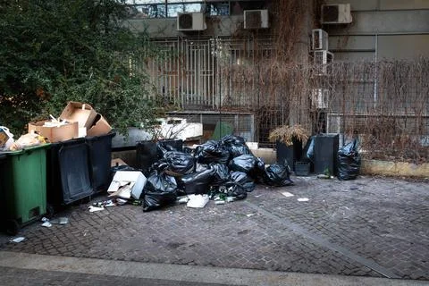 Big plastic dumpsters garbage can full of overflow litter polluting the str.. Stock Photos