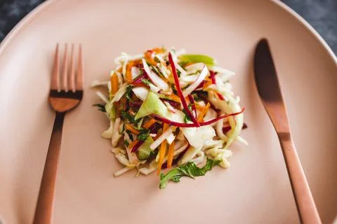 Big plate with small amount of salad in the centre, dieting and calorie restr Stock Photos