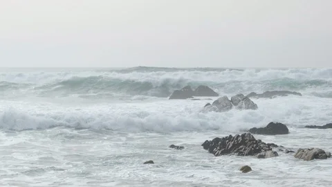 Big, powerful waves in slow motion, splashing against rocks in ocean 動画素材 127128159