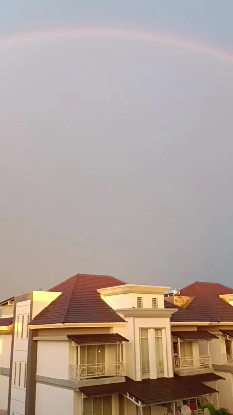 Big rainbow on the blue sky. Vertical video. Video stock 272201392
