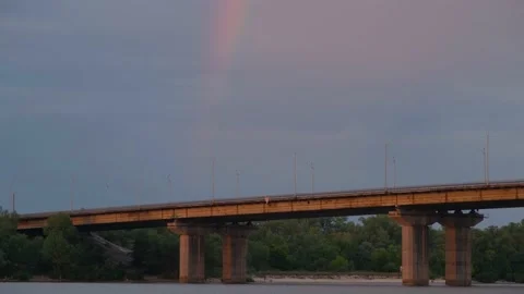 Big rainbow over the old bridge. Road bridge across the river. Rainbow over the Stock Footage 224933741