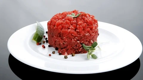 Big raw hamburger cutlet with sprouts and chilli pepper over bla Vídeos de archivo 88897206